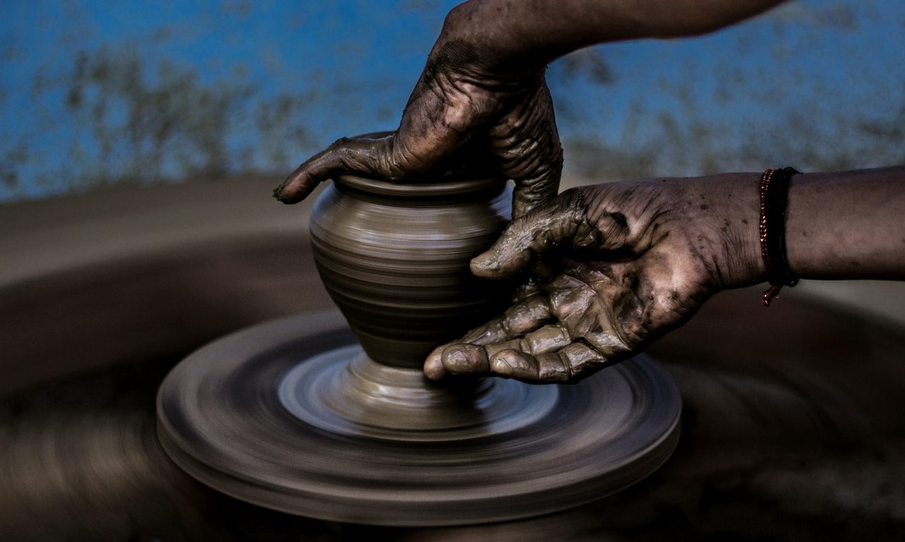 Hands shaping clay on the wheel
